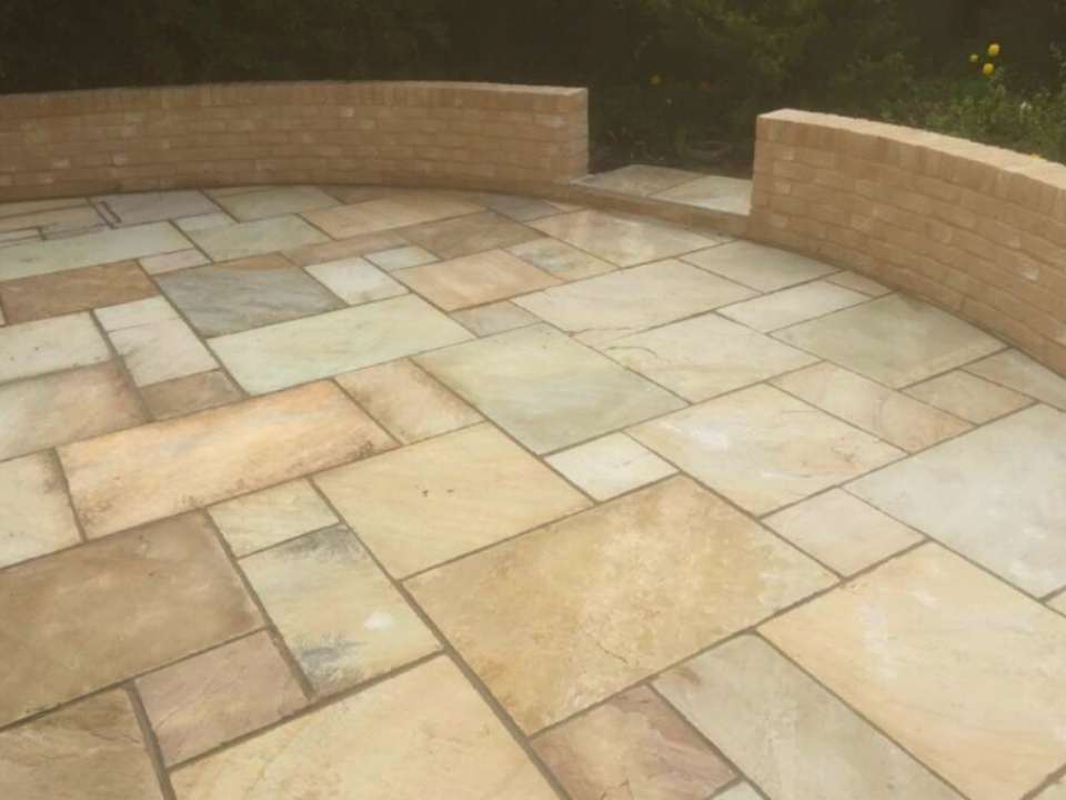 Curved patio with brick retaining wall in Suffolk