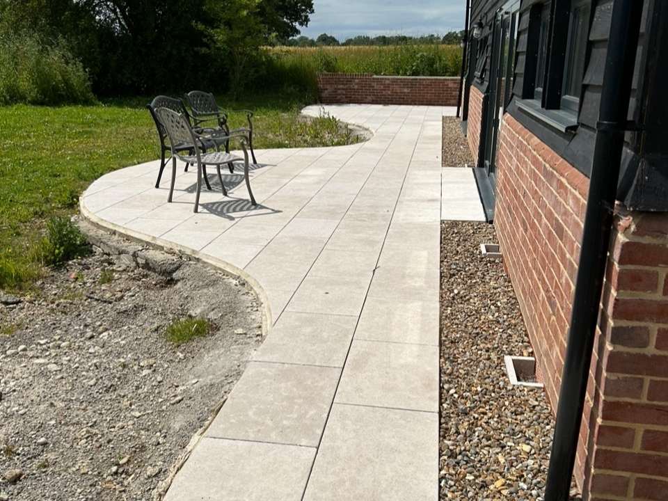Modern patio pathway beside brick wall in Suffolk